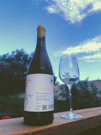 a bottle of wine next to a glass of wine