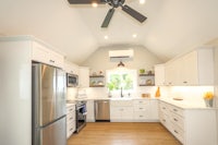 a kitchen with white cabinets and a ceiling fan