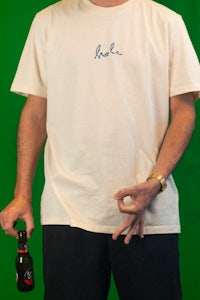 a man holding a beer and a t - shirt