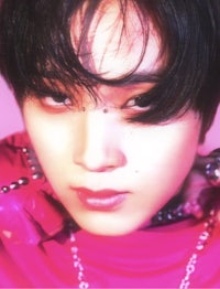 a young man with black hair and a pink shirt