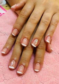 a woman's hands with white and pink nails