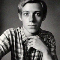 a young man in a plaid shirt is posing for a photo