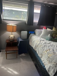 a small bedroom with a bed and a chair next to a window