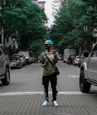 a man standing on a street with a cell phone in his hand