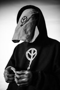 a man wearing a hoodie with a peace symbol on it