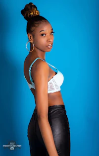 a young black woman in leather pants posing for a photo