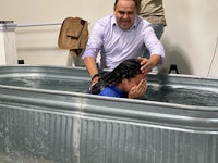 a man is baptizing a woman in a tub