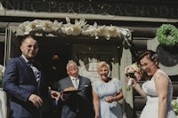 a bride and groom standing outside of a building