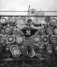 a man standing in front of a fence with a lot of wheels