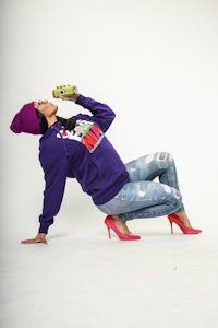 a woman wearing a purple hoodie and jeans
