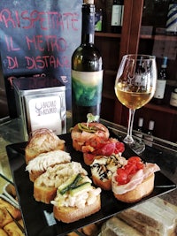 a plate of appetizers and a glass of wine on a table