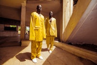 two men in yellow suits standing in a building