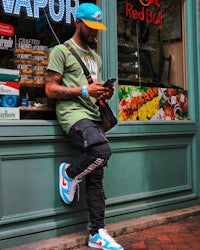 a man leaning against a store front