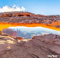 an arch in a rock formation with a view of the desert