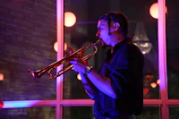 a man playing a trumpet in front of a window