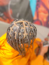 a person with braided hair sitting in a chair