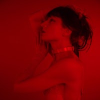 a woman in a lingerie posing in front of a red wall