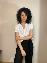 a young woman wearing a white shirt and black pants