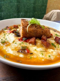 a bowl of soup with a piece of meat on top