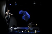 a man and a woman are standing on a stage in front of a light