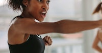 two women doing a boxing exercise in a gym