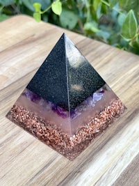an amethyst pyramid on top of a wooden table