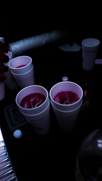 a person pouring a drink into a cup