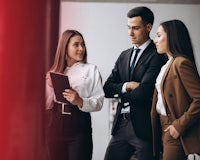 three business people looking at a tablet in an office