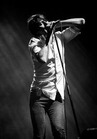 black and white photo of a man singing into a microphone