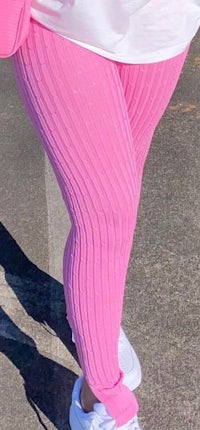 a woman wearing pink ribbed leggings and white sneakers