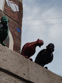 three statues of birds sitting on a ledge