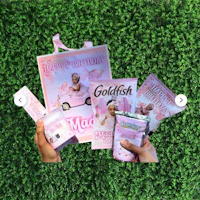 a person holding a goldfish birthday gift set on grass
