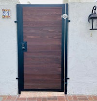 a wooden gate with a black door