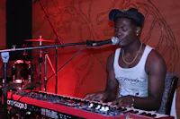 a man playing a keyboard in front of a microphone