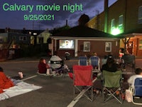 a group of people watching a movie in a parking lot