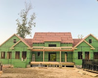 a house under construction with green siding