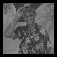 a black and white photo of a young man wearing a floral shirt