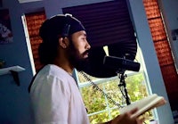 a man with a beard in front of a microphone