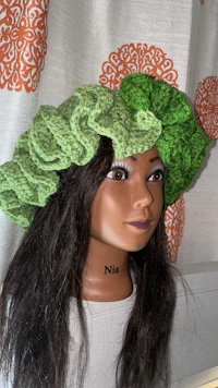 a mannequin wearing a green crocheted hat