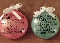 two glass ornaments that say baby is in heaven
