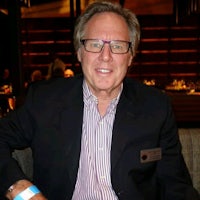a man in glasses sitting on a couch in a restaurant