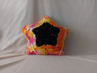 a crocheted star pillow on a bed