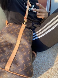 a woman holding a louis vuitton bag