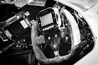 a black and white photo of a steering wheel in a race car