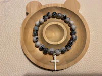 a bracelet with a cross on a wooden plate