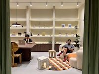 an office with two people sitting in chairs and a rug