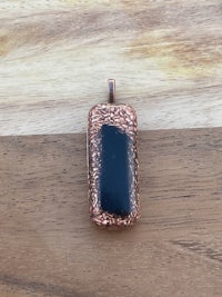 a black onyx pendant on a wooden table