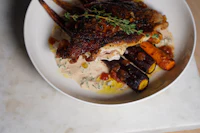 a white plate with chicken and vegetables on it