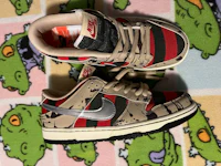 a pair of nike sb dunk low sneakers on a carpet