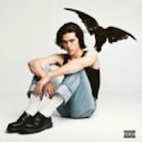 a man sitting on the ground with a bird on his head